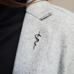 Snake coiled on stick, showing scales and texture | Moon Raven