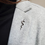 Snake coiled on stick, showing scales and texture | Moon Raven