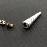 Metallic cylindrical object on a textured black surface