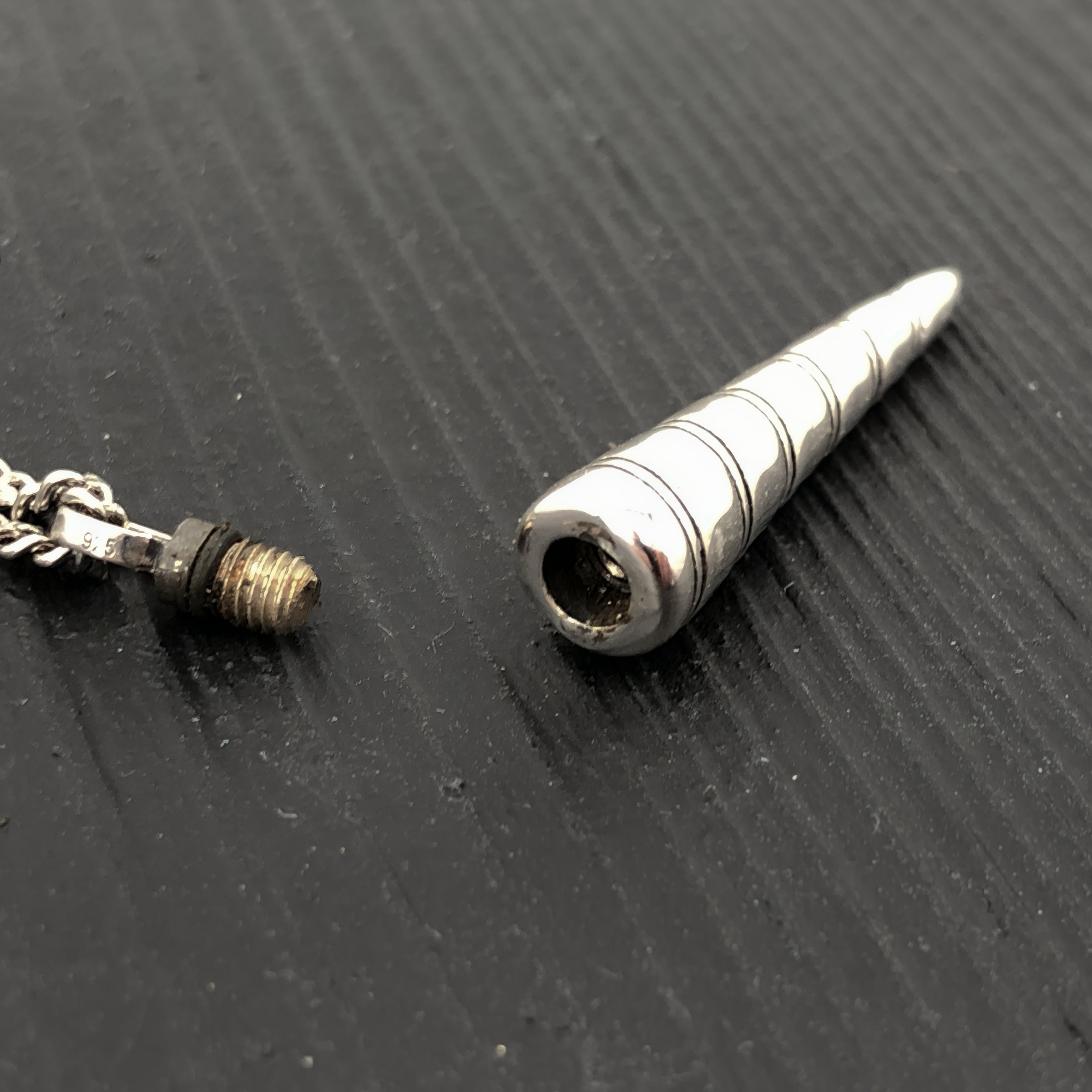 Metallic cylindrical object on a textured black surface