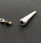 Metallic cylindrical object on a textured black surface